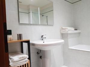 a white bathroom with a sink and a mirror at Appartamento Otelia in Cremona +27 photos