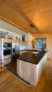 une grande cuisine avec une grande île au milieu dans l'établissement La villa Grand Ouest, à Plounéour-Trez