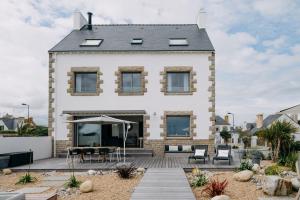 a house with a deck and a patio at Villa Cotton-vue mer et jacuzzi-6ch in Plobannalec-Lesconil