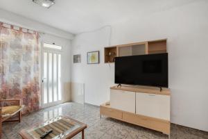 ein Wohnzimmer mit einem Flachbild-TV an einer weißen Wand in der Unterkunft Casa de Jordan in Castillo del Romeral
