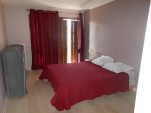 a bedroom with a red bed and a window at Appartement T3 in Embrun