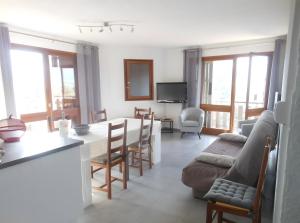 a kitchen and living room with a table and chairs at Appartement T3 in Embrun