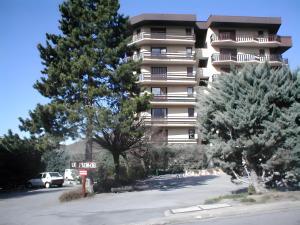 a tall apartment building with trees in front of it at Appartement T3 in Embrun