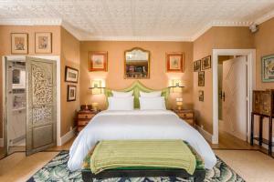 une chambre avec un grand lit avec une tête de lit verte dans l'établissement Domaine De La Boissière, à Trouville-la-Haule