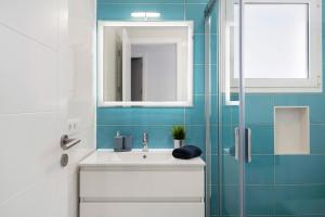 een badkamer met een witte wastafel en een spiegel bij Noray 2 in La Santa +15 foto's