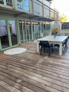 een houten terras met een picknicktafel op een huis bij Magnifique villa avec piscine pour2 à 13 personnes in Bourg-en-Bresse