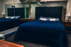 a large blue bed in a room with mirrors at Treasure State Hostel in Bozeman