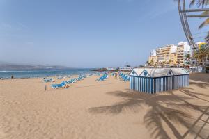Ein Strand mit einem Haufen Stühle und Menschen darauf in der Unterkunft Siempreviva Beach Las Canteras in Las Palmas de Gran Canaria