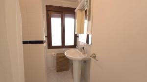 a white bathroom with a sink and a window at Villa Los Gemelos in Calpe +19 photos