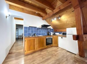 a kitchen with wooden cabinets and a wooden ceiling at Chez Fred 202 - Parking Wifi Balcon in Saint-Pierre-dʼAlbigny