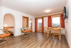 a room with a table and chairs and a bedroom at Zolerhof in Feldthurns