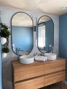 une salle de bain avec deux lavabos et un grand miroir dans l'établissement Villa Grande Est idéal famille Spa, à Plounéour-Trez