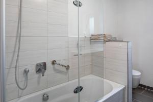 a bathroom with a shower with a tub and a toilet at Ferienwohnung Sonnenseite in Ihringen +16 photos