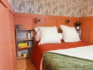 a bedroom with two beds and a book shelf at Le petit logis in Folligny