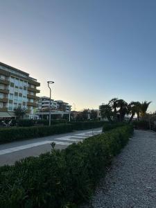 a city street with a building and palm trees at Tra Cielo e Mare da Vale in Fano