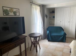 sala de estar con TV de pantalla plana y taburete en Gîte L'écluse - La Noria, en Cazouls-lès-Béziers