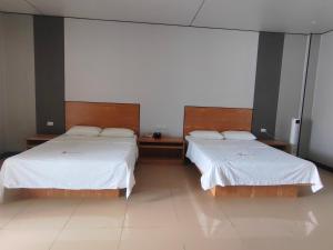 mermaidN2 في هونيارا: سريرين في غرفة مع ملاءات بيضاء