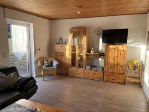 a living room with a flat screen tv and wooden cabinets at Ferienhaus Ahoi in Hooksiel