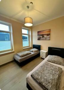 two beds in a room with two windows at Wohnung am Bahnhof Schwerte in Schwerte