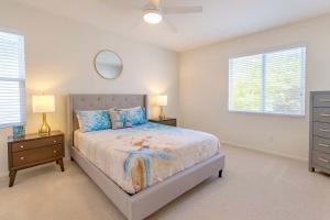 ein Schlafzimmer mit einem Bett, zwei Lampen und einem Spiegel in der Unterkunft Allura Del Mar Heights Pet-Friendly 5BR Retreat in Del Mar + 15 Fotos