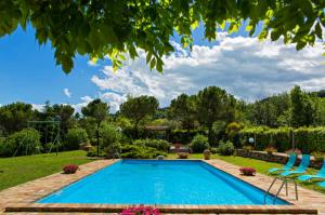 a swimming pool in a yard with two lawn chairs at Italian Experience-Villa Incanto in Potenza Picena