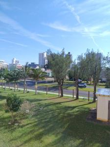 Blick auf einen Park mit Bäumen und eine Straße in der Unterkunft Refúgio a beira-mar in Tramandaí