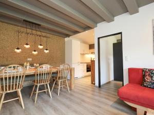 une salle à manger et une cuisine avec un canapé et des chaises rouges dans l'établissement Tirola Platzl, à Hopfgarten im Brixental 24 autres photos