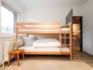 une chambre avec un lit superposé et une table dans l'établissement Tirola Platzl, à Hopfgarten im Brixental