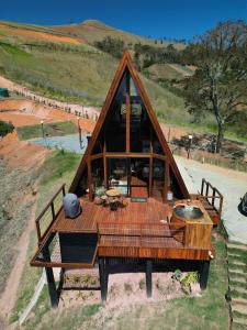 a house with a wooden roof with a table at Cabana Quatro Estações - Luxo Romântica e com vista incrível in Paty do Alferes +36 photos