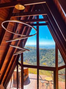 Zimmer mit einem großen Fenster und einem Kronleuchter in der Unterkunft Cabana Quatro Estações - Paty do Alferes - Rio de Janeiro in Paty do Alferes
