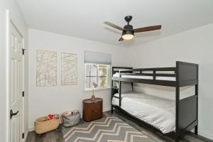 1 Schlafzimmer mit 2 Etagenbetten und einem Deckenventilator in der Unterkunft Evergreen Escape Cabin for families in Sugarloaf