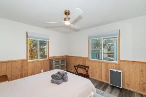 1 Schlafzimmer mit einem weißen Bett und 2 Fenstern in der Unterkunft Evergreen Escape Cabin for families in Sugarloaf + 26 Fotos