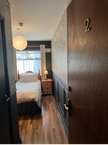 Rooms Foxford في فوكسفورد: غرفة نوم صغيرة بها سرير ونافذة