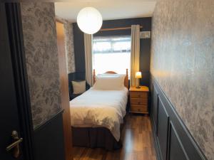 Rooms Foxford في فوكسفورد: غرفة نوم صغيرة بها سرير ونافذة