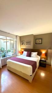 Un dormitorio con una cama grande y una ventana grande. en Hotel Juliette Bogota Chapinero, en Bogotá