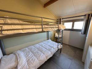 Una litera en una habitación pequeña con ventana. en Westhinder II H18, en Koksijde