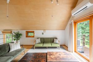 a living room with a couch and a table at Poroto House in Nanae