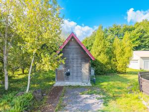 une petite maison avec un toit rouge dans une cour dans l'établissement Poroto House, à Nanae