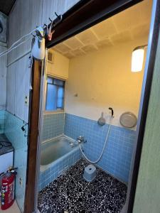 a bathroom with a tub and a toilet in it at 九州 福岡 貸切 プライベートハウス  +14 photos