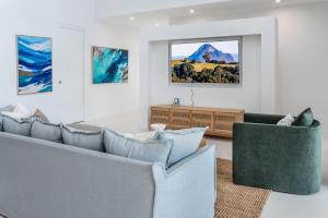 een woonkamer met twee banken en een tv bij Luxury Pool Home Near Noosa & Coolum Sleeps 8 in Peregian Springs