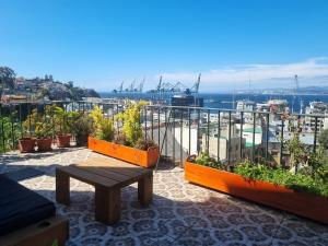 a patio with a bench and plants on a balcony at Comfortable and family house in Cerro Alegre in Valparaíso