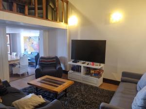 a living room with a couch and a tv at Comfortable and family house in Cerro Alegre in Valparaíso