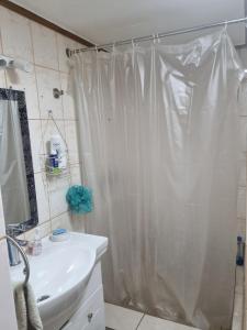 a bathroom with a shower curtain and a sink at Comfortable and family house in Cerro Alegre in Valparaíso +5 photos