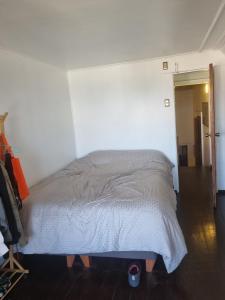 a bed in a room with a person standing next to it at Comfortable and family house in Cerro Alegre in Valparaíso