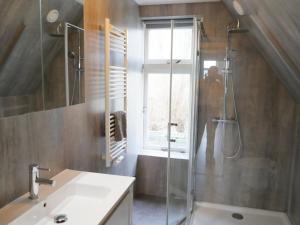 a bathroom with a shower and a sink and a window at Bollenzicht in Breezand +32 photos