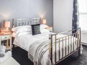 een slaapkamer met een bed en twee nachtkastjes bij Fuchsia Cottage in Sea Palling