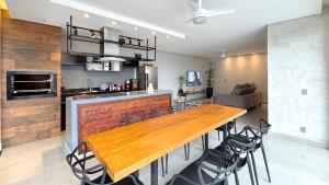 eine Küche mit einem Holztisch und einigen Stühlen in der Unterkunft Casa em Foz do Iguaçu com piscina, churrasqueira e natureza ao redor para sua família in Foz do Iguaçu + 15 Fotos