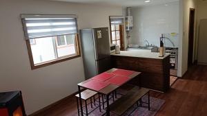 プエルト・アイセンにあるCabaña Moderna en el bosqueのテーブルと冷蔵庫のあるキッチン