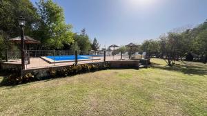 a yard with a swimming pool and a garden at Cabañas Aldea Blanca in Merlo