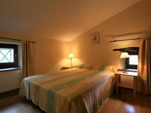 a bedroom with a large bed and a window at Maison de caractère avec terrasse à 300m de l'Allier, idéale pour pêche, détente et activités familiales - FR-1-582-208 in Villeneuve-dʼAllier